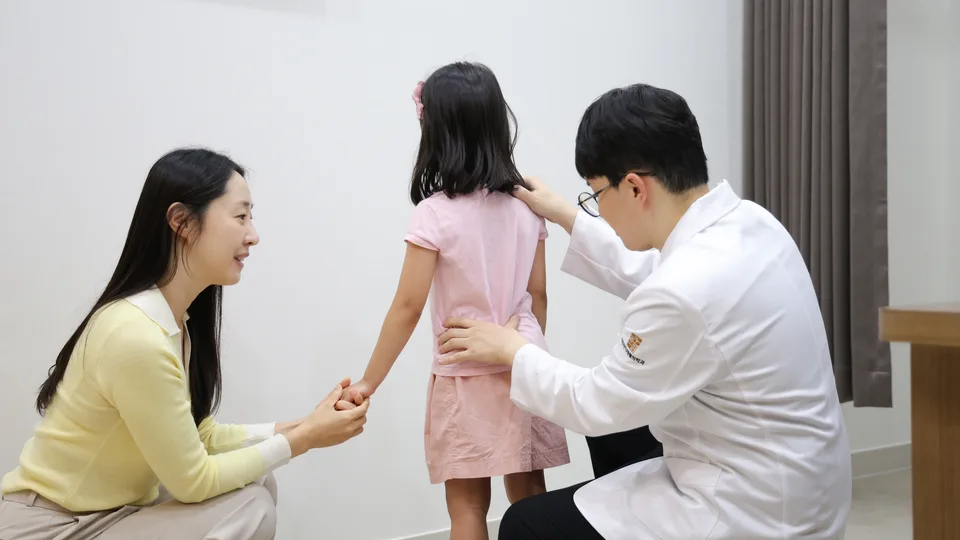 고든마디 의료진이 보호자와 함께 영아의 목 움직임과 머리 모양을 확인하는 실제 장면
