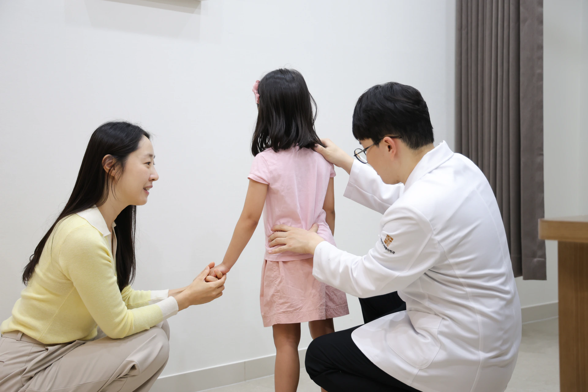 고든마디재활의학과의원에서 보호자와 함께 아동의 척추와 자세를 확인하는 진료 장면