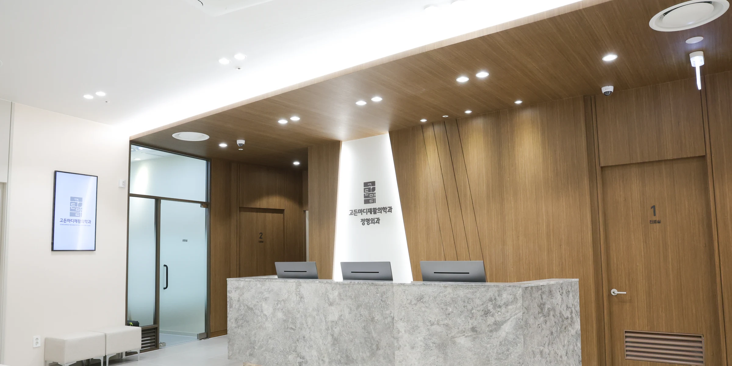 Gordonmadi clinic reception area with a stone desk and wood-paneled walls